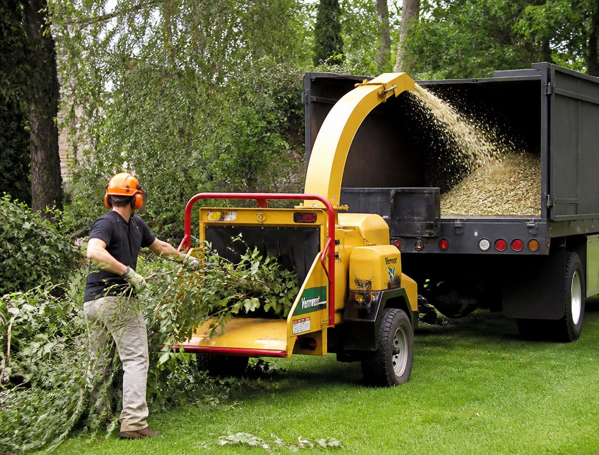 Broyeur de branches projetant les copeaux dans une benne de camion