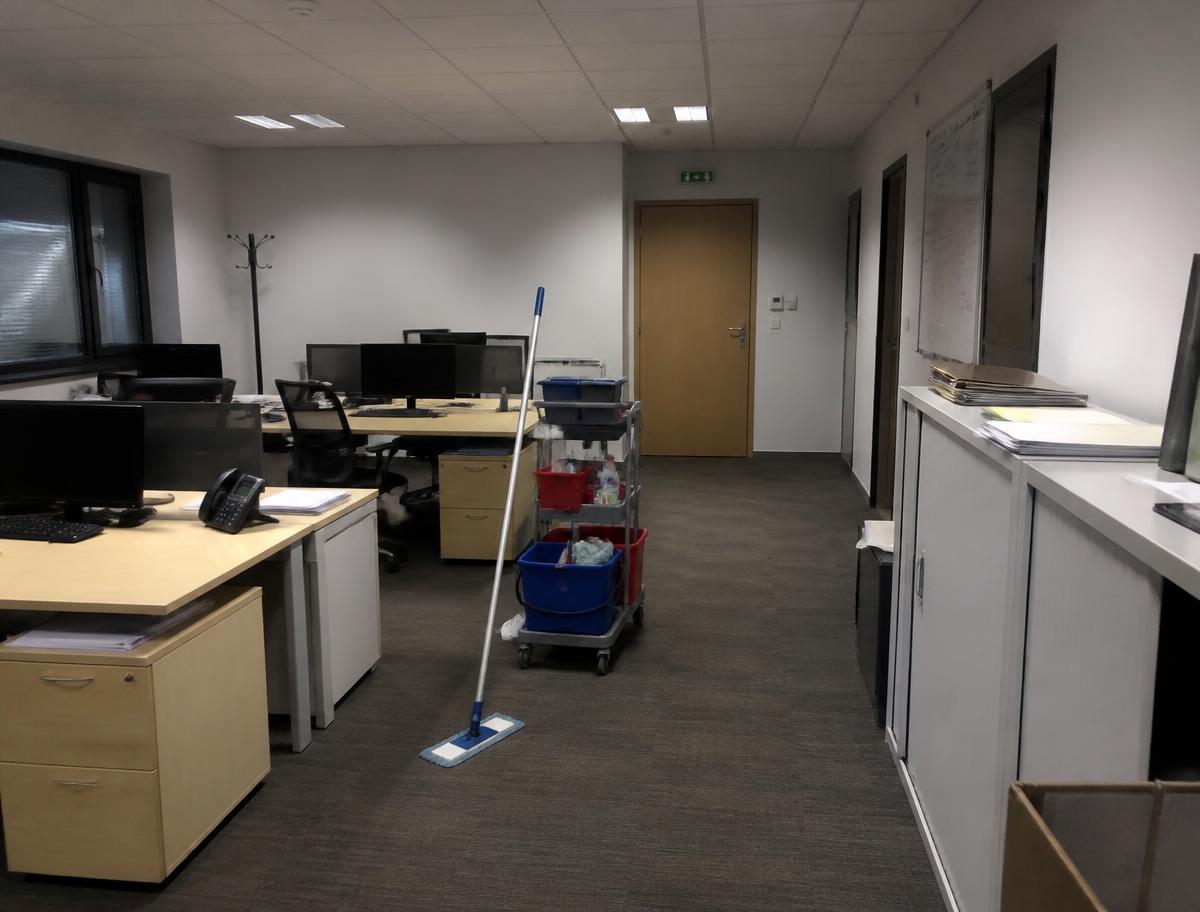Bureaux nettoyés en fin de journée avec chariot de ménage dans l'allée
