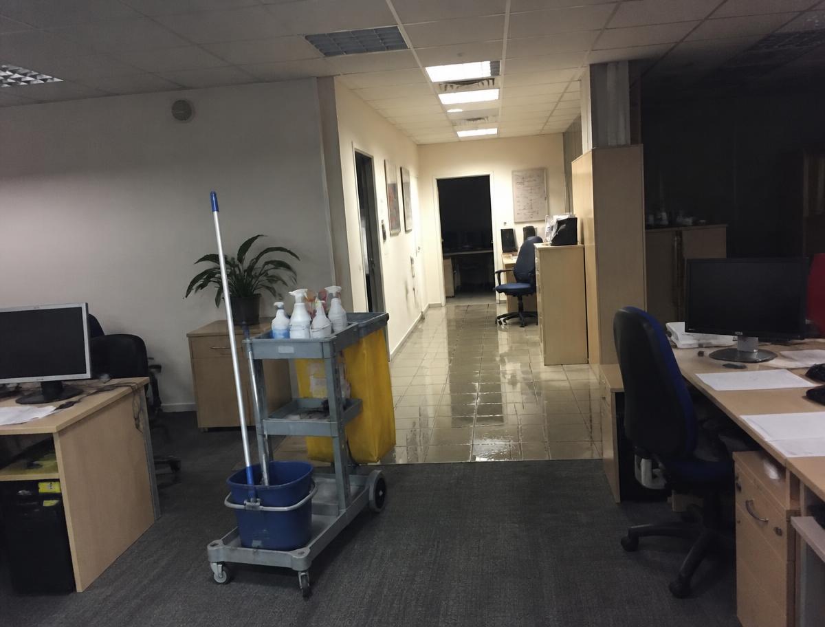 Chariot de ménage dans un couloir de bureaux nettoyé en fin de journée