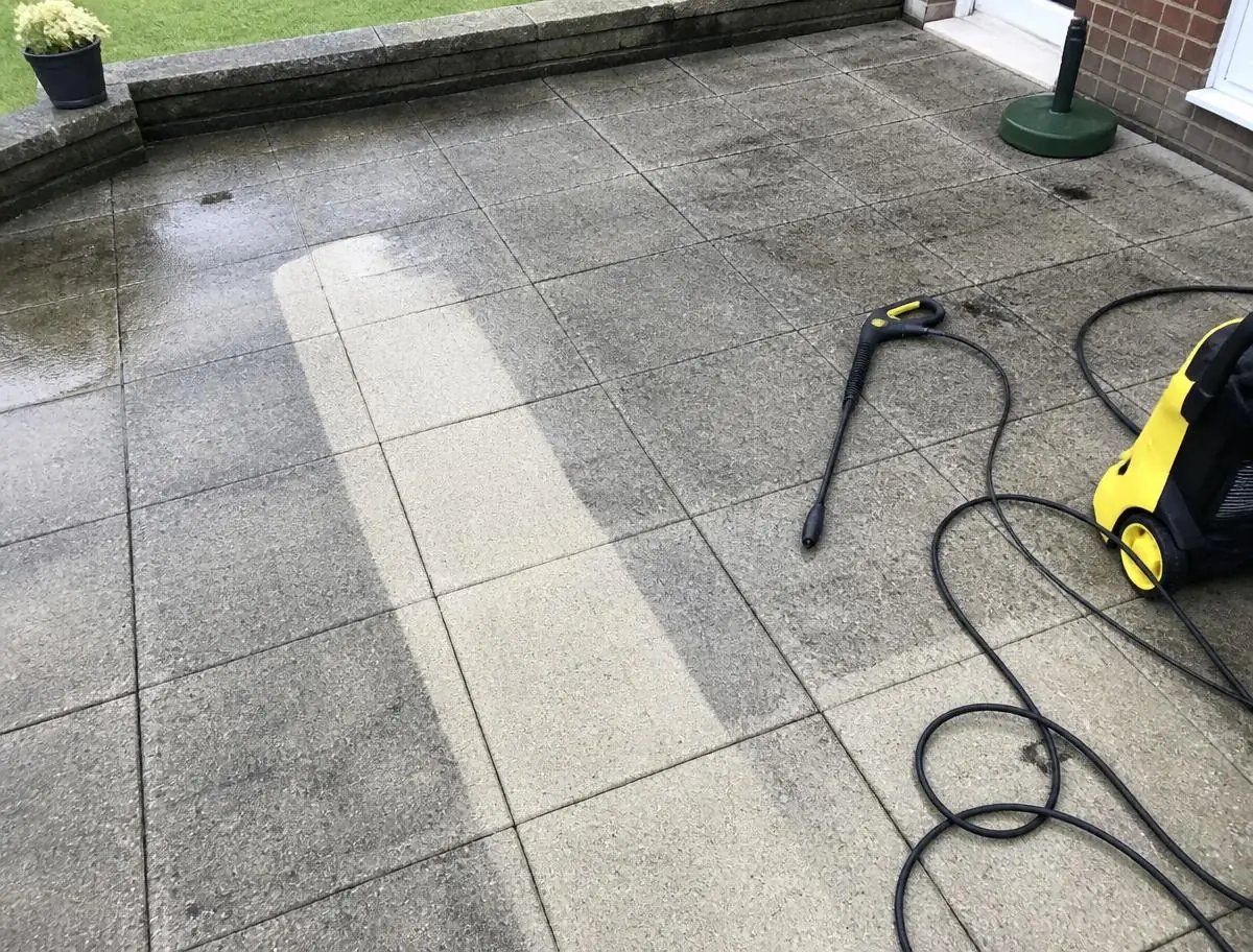 Dalles de terrasse nettoyées au nettoyeur haute pression, bande propre bien visible